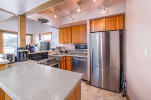 a kitchen with a stainless steel refrigerator and wooden cabinets at Country House 071 in Black Butte Ranch