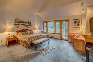 a bedroom with a bed and a desk and windows at East Meadow 017 in Black Butte Ranch