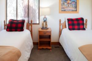a room with two beds and a lamp on a night stand at Country House 073 in Black Butte Ranch +7 photos