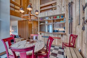 a dining room with a wooden table and red chairs at Country House 073 in Black Butte Ranch