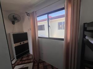 a room with a window and a television at JO's HOMEtel SL 1 in Sampong
