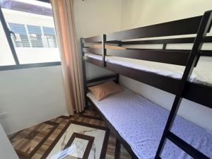 a small room with two bunk beds and a mirror at JO's HOMEtel SL 1 in Sampong