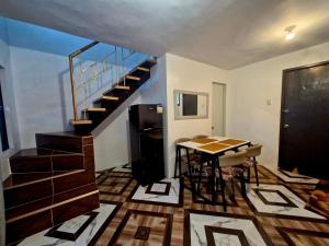 a living room with a table and a staircase at JO's HOMEtel SL 1 in Sampong