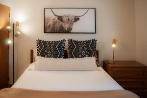 a bedroom with a bed with a picture of a bull at Country House 071 in Black Butte Ranch
