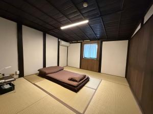 ein Zimmer mit einem Bett in der Mitte in der Unterkunft ほぼ家 in Tsuruga