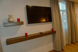 a living room with a television on a wall at Hotel Tres Reinas in Xicotepec de Juárez