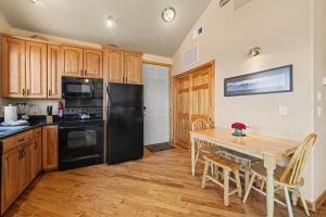 a kitchen with a table and a black refrigerator at Teepee Mountain 12A Condo in Estes Park