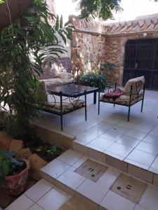 a table and two benches on a patio at Keur Fall Aéroport in Saint-Louis