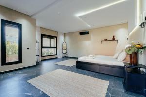 a bedroom with a bed and two rugs at Atlas Serenity Villa Marrakech in Sbiti +15 photos
