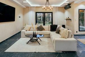 a living room with two couches and a tv at Atlas Serenity Villa Marrakech in Sbiti