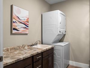 a kitchen with a sink and a washer and dryer at TC Parkside G: Spacious 2BR Condo in Traverse City +40 photos