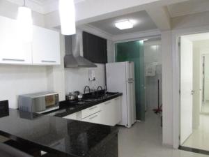 a kitchen with a white refrigerator and a microwave at Bombinhas summer bech in Bombinhas