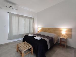 a bedroom with a bed and a chair and a window at Algarrobos in Cafayate +30 photos