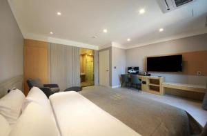 a hotel room with a bed and a flat screen tv at 아셈호텔 in Taech'on