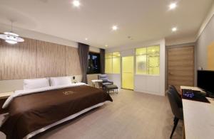a hotel room with a bed and a desk and chairs at 아셈호텔 in Taech'on