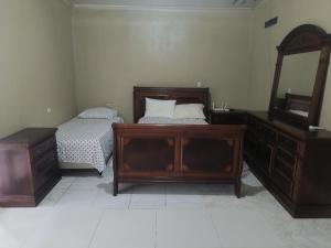 a bedroom with a bed and a dresser and a mirror at Ana' House in Bluefields