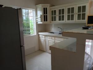a kitchen with white cabinets and a sink at Ana' House in Bluefields