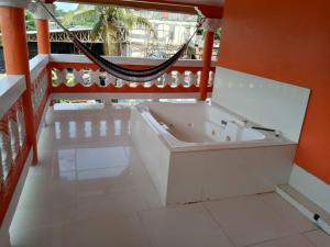 a white bath tub in a room with a hammock at Ana' House in Bluefields +28 photos