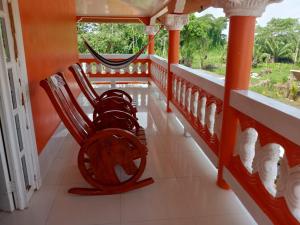 a porch with two rocking chairs on a house at Ana' House in Bluefields