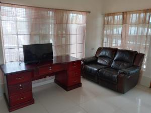 a living room with a desk and a leather couch at Ana' House in Bluefields