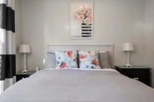 a bedroom with a large white bed with two lamps at SkyBox|Rooftop|Downtown in Traverse City