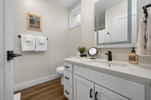 a white bathroom with a sink and a mirror at SkyBox|Rooftop|Downtown in Traverse City +50 photos