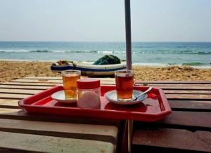 a tray with two drinks on a table at the beach at Dolphin beach resort in Varkala