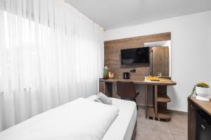 a hotel room with a bed and a desk with a tv at Hotel Löwenstein in Lich