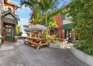 a picnic table with an umbrella next to a building at Glebe Terraces in Sydney