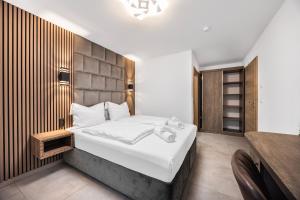 a bedroom with a large bed and a wooden wall at Hotel Löwenstein in Lich