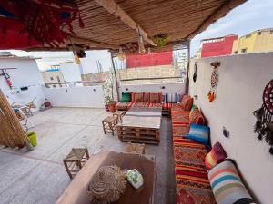a living room with couches and tables on a roof at Jurassic Surf House Anza in Agadir
