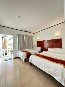 a hotel room with two beds and a window at Gracey Dive Resort and Restaurant in Dauin +61 photos