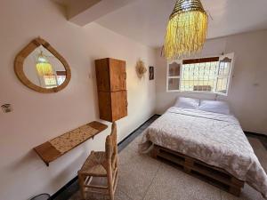 a bedroom with a bed and a mirror and a chandelier at Jurassic Surf House Anza in Agadir