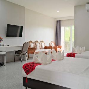 a hotel room with two beds and a television at โกลเด้นแลนด์รีสอร์ท in Ban Dan Kwian