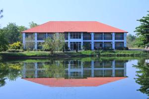 a house with a reflection in the water at โกลเด้นแลนด์รีสอร์ท in Ban Dan Kwian