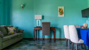 a living room with a couch and a table with chairs at Lamblion Holiday Apartment in Freemans