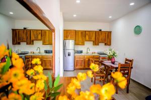 a kitchen with wooden cabinets and a table with yellow flowers at Sanpanchobungalows in San Francisco