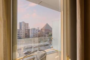 a window with a view of a city at TAJ Suites Pyramids View Hotel in Cairo +79 photos