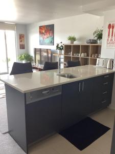 a kitchen with a large island with a sink at Harbourview Penthouse Apartment in Whitianga