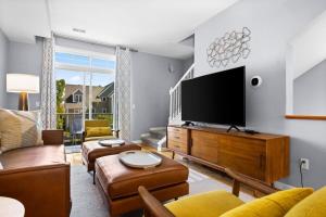 a living room with a large flat screen tv at Midcentury Getaway: Walk to Everything! in Traverse City