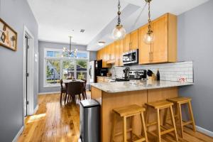 a kitchen with wooden cabinets and a counter with stools at Midcentury Getaway: Walk to Everything! in Traverse City