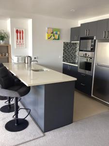 a kitchen with a counter with a sink and appliances at Harbourview Penthouse Apartment in Whitianga