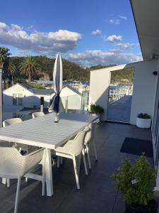 a white table and chairs on a balcony at Harbourview Penthouse Apartment in Whitianga