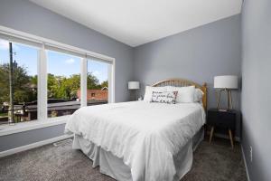 a bedroom with a bed and a large window at Midcentury Getaway: Walk to Everything! in Traverse City