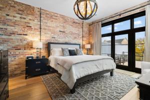 a bedroom with a brick wall and a bed at Luxury TC Loft: Historic Condo! in Traverse City