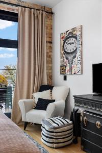 a bedroom with a chair and a clock on the wall at Luxury TC Loft: Historic Condo! in Traverse City