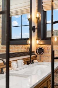 a bathroom with a sink and two windows at Luxury TC Loft: Historic Condo! in Traverse City +81 photos
