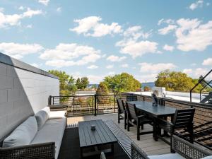 a patio with a couch and a table on a roof at Luxury TC Loft: Historic Condo! in Traverse City