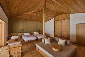 a living room with two beds and a couch at AZUMA FARM Koiwai in Shizukuishi
