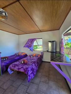 a room with two beds and a tv in it at Pension Tipapa in Tikehau +12 photos